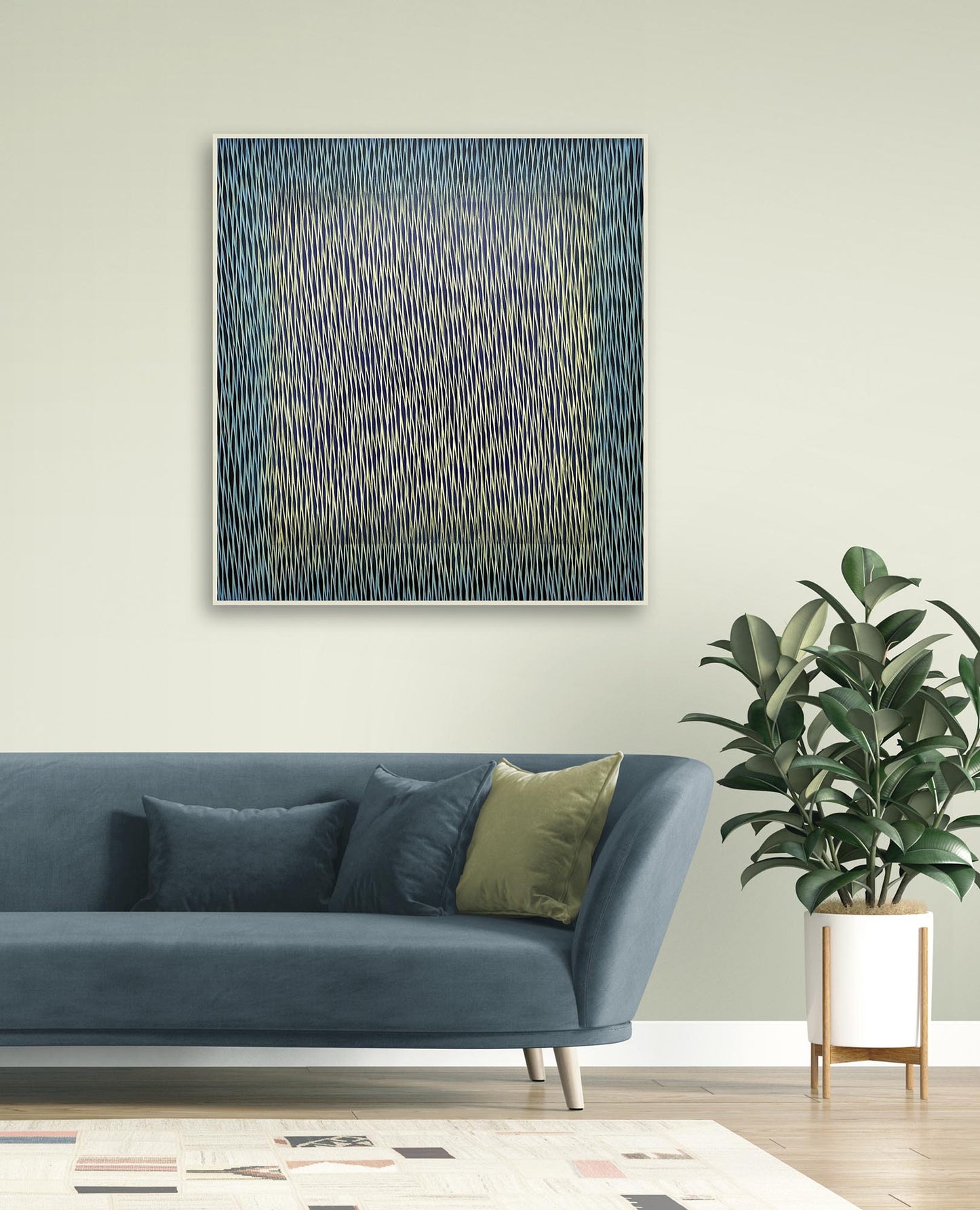 Abstract painting on a wall above a blue sofa with decorative pillows and a plant.