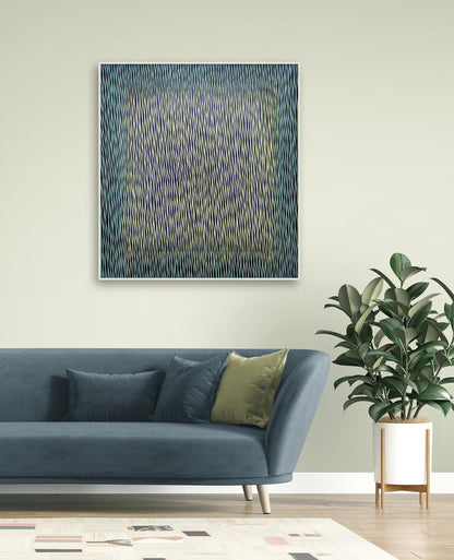 Abstract painting on a wall above a blue sofa with decorative pillows and a plant.
